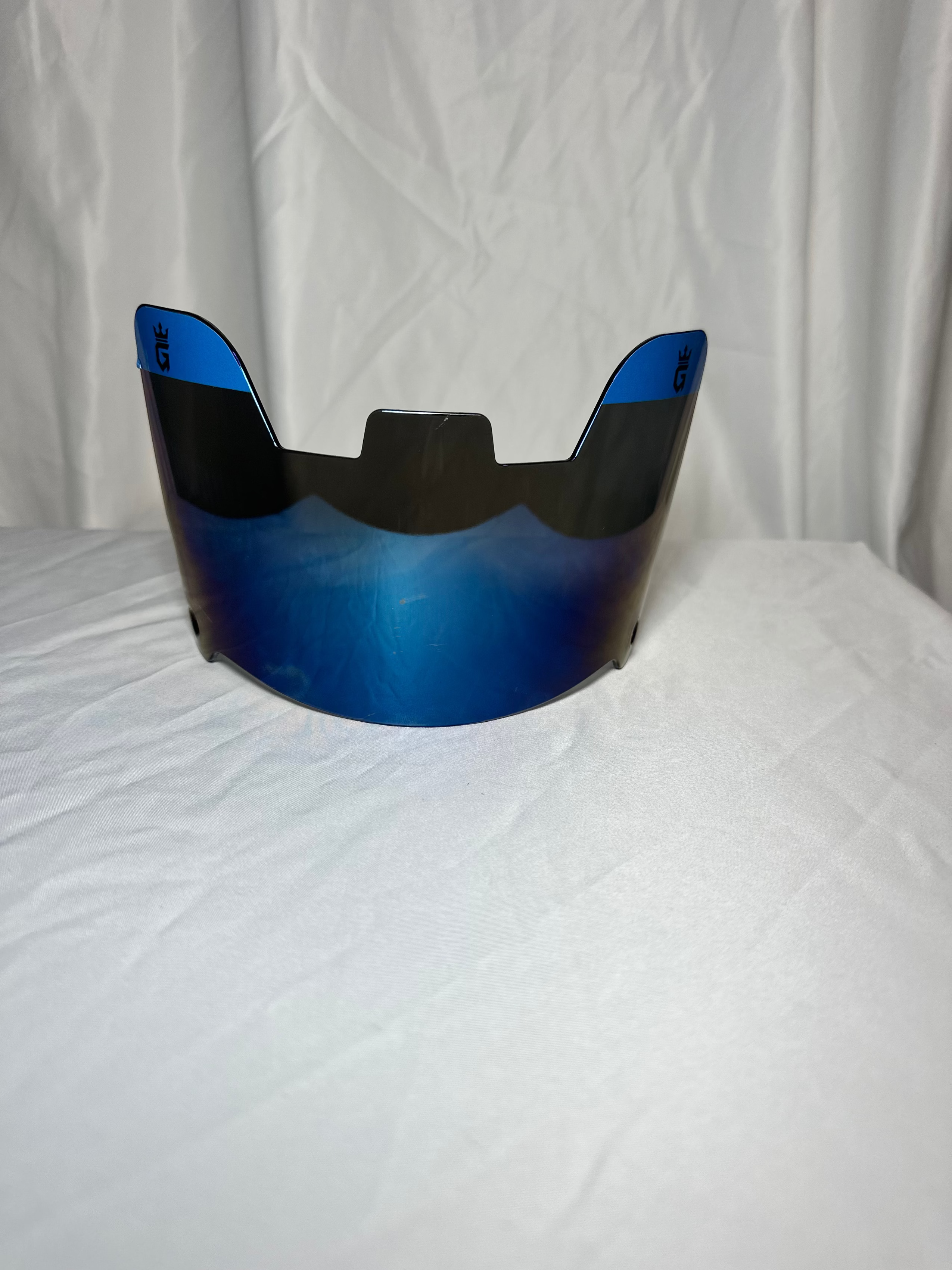 Blue and black helmet visor on a white background